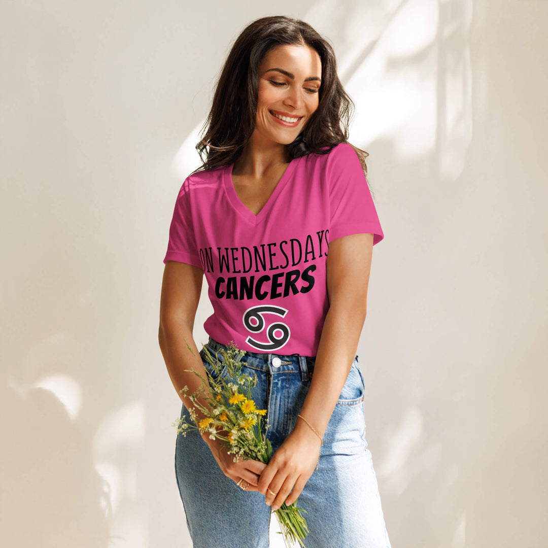 Woman wearing a pink t-shirt with 'On Wednesdays Cancer' text and holding flowers, standing against a light background.