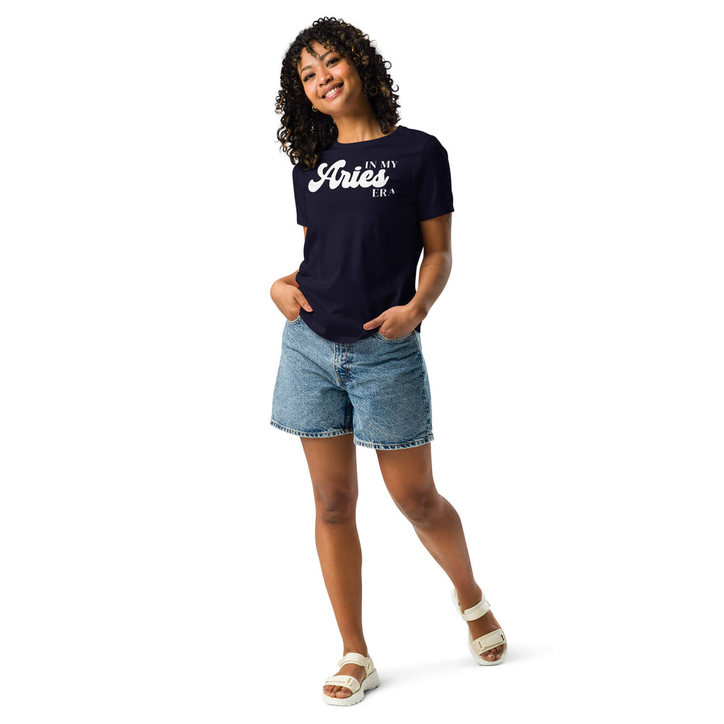 Woman wearing "In My Aries Era" Aries zodiac graphic t-shirt in navy blue with denim shorts, women's astrology apparel