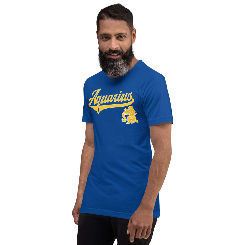 A man with a beard wearing a royal blue t-shirt with a yellow 'Aquarius' graphic and a gold mascot, set against a plain white background.