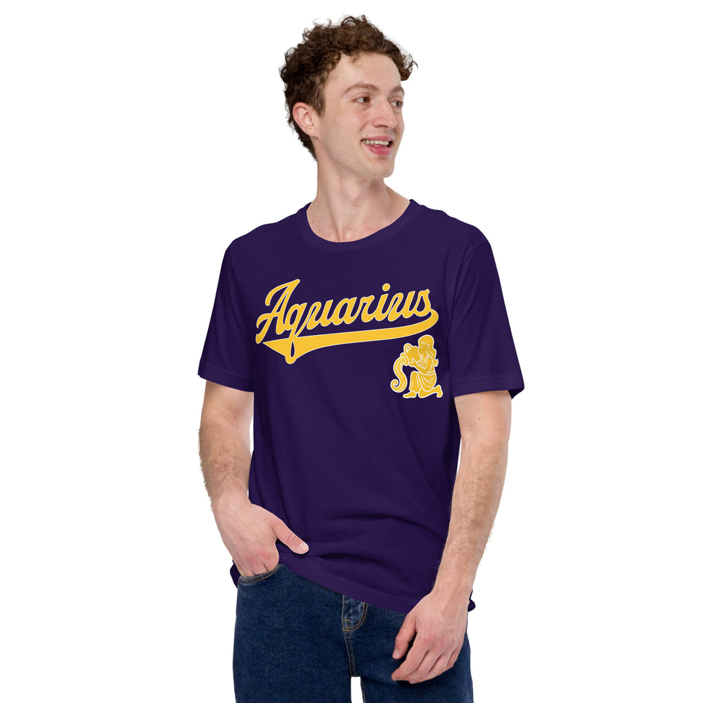 A man wearing a dark purple t-shirt with a gold 'Aquarius' graphic and mascot on the front, paired with blue jeans, against a plain white background.