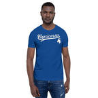 A man wearing a royal blue crewneck t-shirt with 'Capricorns' written in white script across the chest, accompanied by a white capricorn graphic on the left chest, paired with blue jeans against a plain white background.