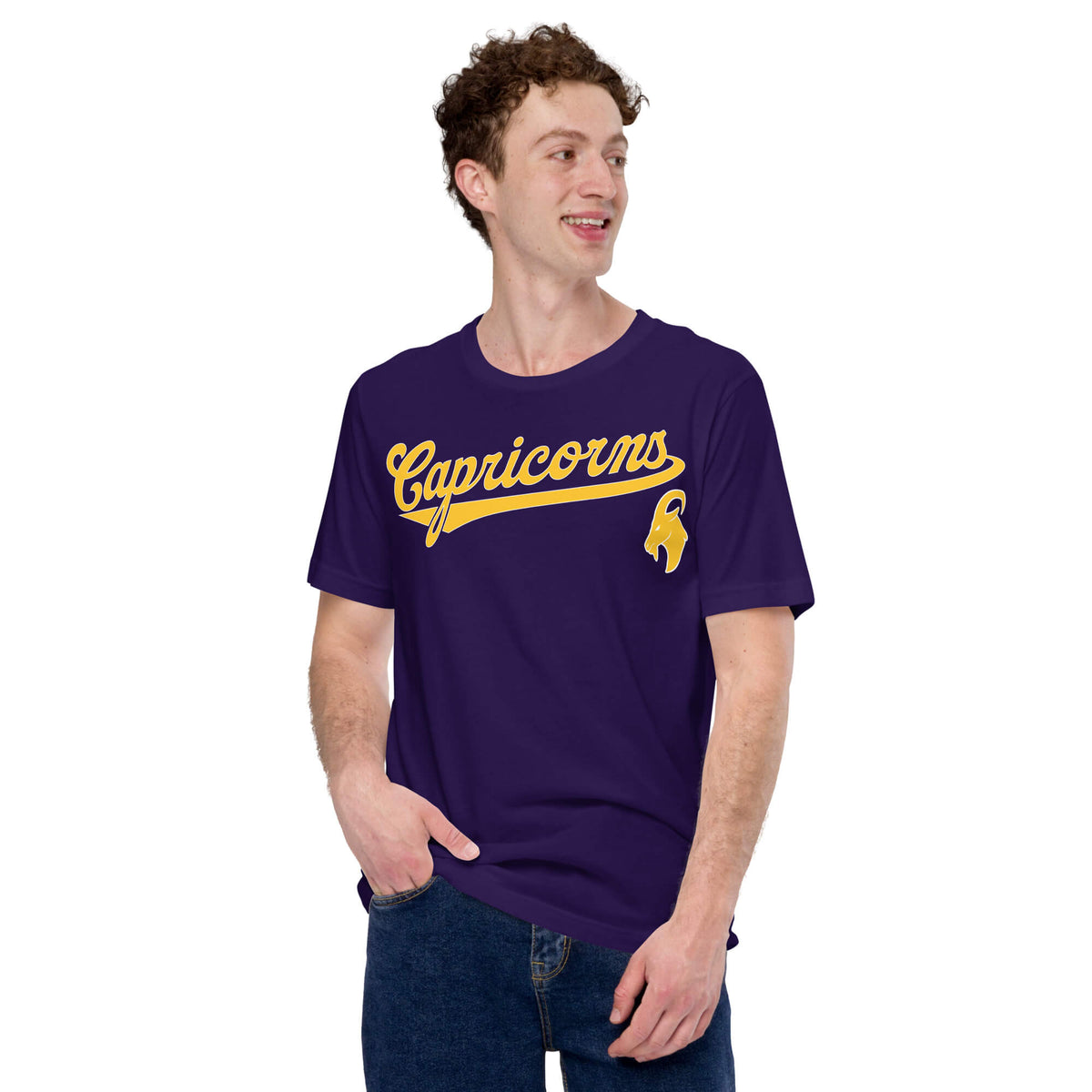 A man wearing a dark purple t-shirt with 'Capricorns' written in gold cursive script across the chest, paired with blue jeans, set against a plain white background.