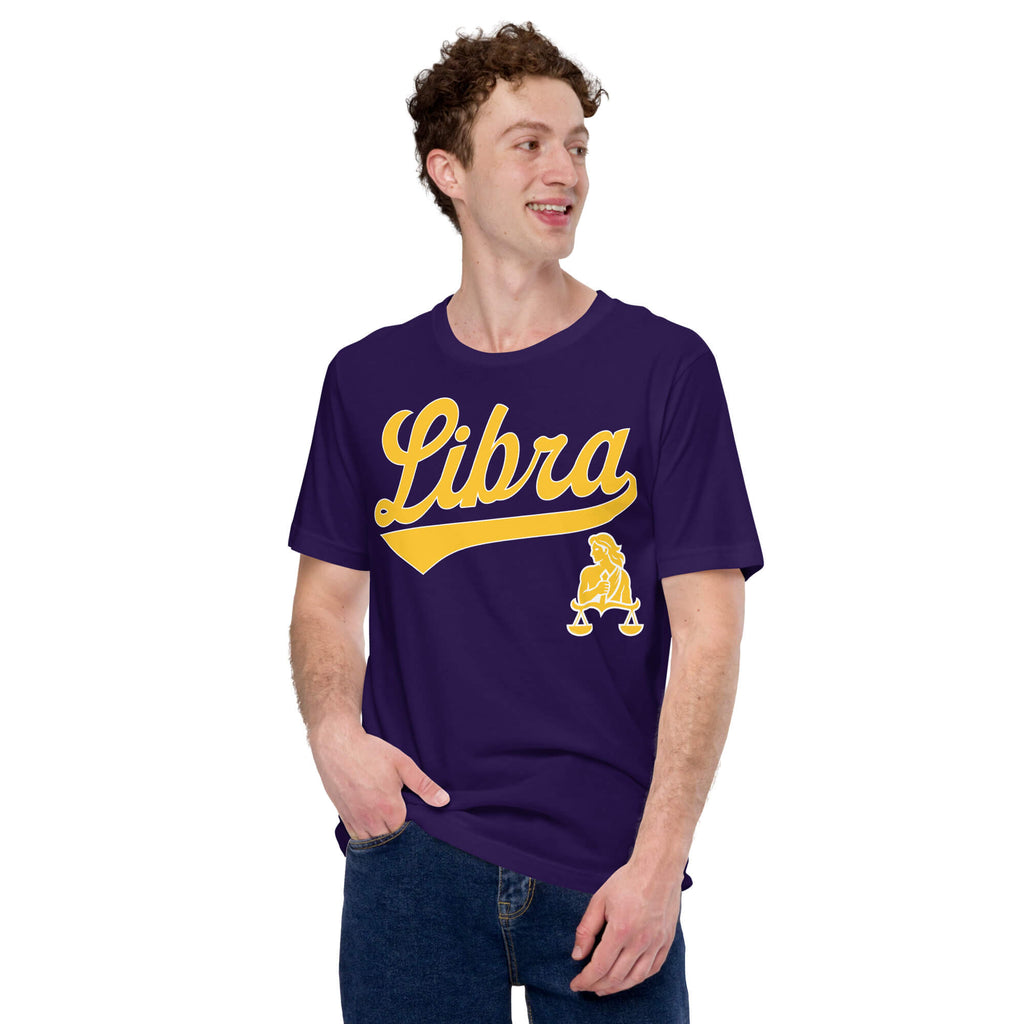 A man wearing a dark purple t-shirt with a gold 'Libra' graphic and a small Libra zodiac symbol on the front, paired with blue jeans, against a plain white background.