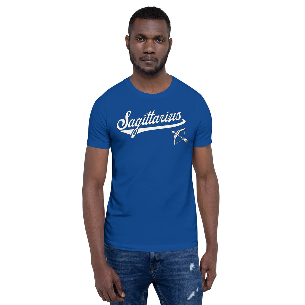 A man wearing a royal blue crewneck t-shirt with a white 'Sagittarius' graphic and an arrow design on the chest, paired with blue jeans, set against a plain white background.