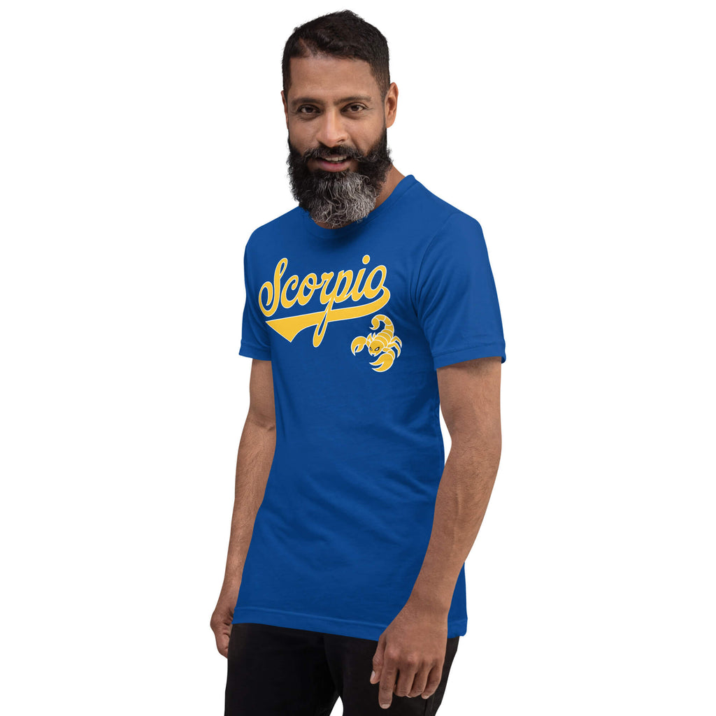 A man with a beard wearing a royal blue t-shirt with a gold 'Scorpio' graphic and scorpion design on the chest, set against a plain white background.