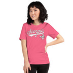 A woman modeling a bright pink short-sleeve t-shirt with 'Scorpio' zodiac graphic. The background is a clean, solid white.